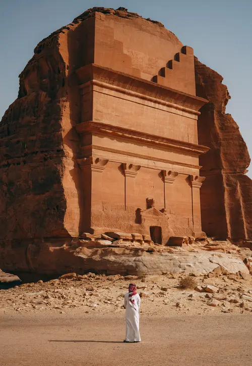 a man standing in front of the Tomb of Lihyan son of Kuza in Saudi Arabia