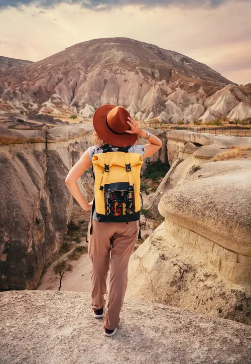 Young woman hiking and enjoying mountain landscape in Cappadocia